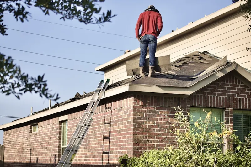 Professional roofer working on a residential roof in Lowell Mill